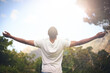 © Tasneem/peopleimages.com - Man, freedom and arms stretched, happiness and appreciate nature in sunlight. Black male person, outdoors and lensflare on vacation for adventure or optimist, grateful and wellness or blue sky