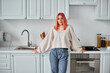 © LIGHTFIELD STUDIOS - good looking jolly woman in casual jumper and jeans posing in kitchen and looking at camera