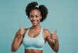 Fit woman in a sports top giving two thumbs-up, signaling her approval and enthusiasm for a healthy lifestyle.