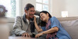 © Natee Meepian - Happy mature husband and wife sit rest on comfortable sofa in living room enjoy talking, smiling elderly couple relax on couch at home chat speak laugh on leisure weekend