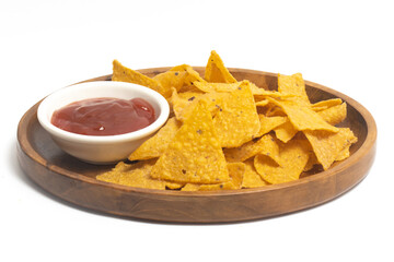 Crispy corn tortilla nachos chips with sauce in a wooden plate isolated on white background clipping path