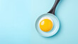 Frying pan with eggs on blue background