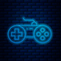 Poster - Glowing neon line Gamepad icon isolated on brick wall background. Game controller. Vector