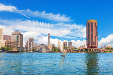 Wall Mural - Typical sailboat in the Nile river and fancy buildings of Cairo, Egypt