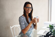 Portrait, woman and coffee for happy, relax and wellness as stress management at desk in office. Entrepreneur, female person and smile for mental health, positive mindset and tea for peaceful rest
