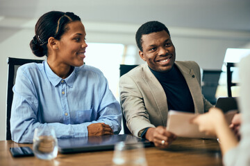 Wall Mural - Smiling black businesspeople having a meeting, talking with some clients.