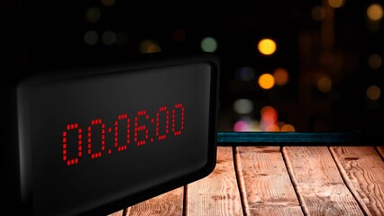 Poster - Animation of digital clock counting down to midnight with lights on black background
