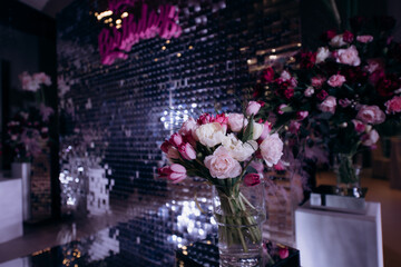 Wall Mural - The wedding reception is decorated with glass vases, filled with white and pink tulips, surrounded by burning candles, which creates an intimate romantic atmosphere, close-up. Photo zone for a couple 