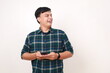 © ArvStd - Happy young asian man holding a cell phone while looking sideways on empty space
