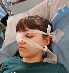 a girl after surgery. portrait of woman wearing white eye patch as protection after injury. eye inju