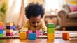© Julia Jones - A photo of an African-American kid playing with colorful cubes and toys lying on the floor