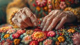 Fototapeta  - Imparting traditions. Scaled up view on hands of a senior lady sitting next to her grandchild holding a needle and embroidering a very beautiful blossoming.