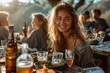 Cheerful woman enjoying a sunset dinner surrounded by friends at an outdoor table