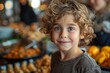 Adorable curly-haired boy smiling with bright eyes in front of a buffet