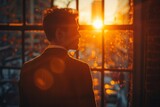 Fototapeta  - A contemplative man silhouetted against a dazzling urban sunset, evoking reflection