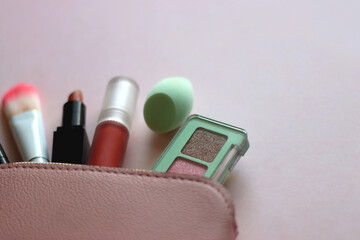 Wall Mural - Pink make up bag with various beauty products. Pink background, selective focus.