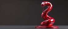 A Red Sculpture Of A Snake Sitting On Top Of A Black Table Next To A Gray Wall With A Black Background.