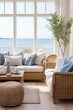 © Vit - A living room filled with furniture and featuring a large window, adorned with coastal-themed nautical decor. The room is bright and airy, with a comfortable sofa, armchairs, coffee table, and a rug