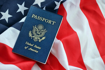 Blue United States of America passport on national flag background close up. Tourism and citizenship concept