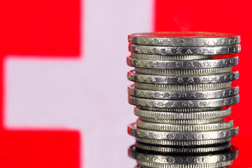 Pile of Swiss francs and the Swiss national flag