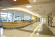 A bright and clean hospital corridor with a modern reception desk and spacious interior.