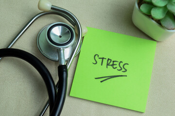 Wall Mural - Concept of Stress write on sticky notes with stethoscope isolated on Wooden Table.