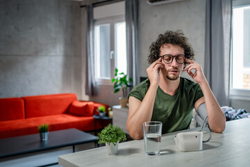 one adult caucasian man measure check blood pressure at home alone