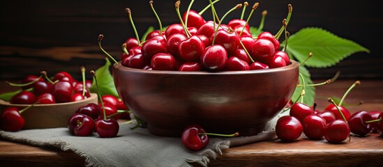 Poster - A vibrant display of fresh cherries filling a rustic wooden bowl that sits on a table. The bright red cherries are ripe and glistening, creating a tempting and appetizing sight.