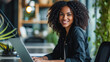 © boxstock production - Photo of beautiful young professional African-American woman with curly hair, smiling, using laptop in bright and stylish office space