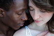 © Centric  - An intimate close-up of a multiracial couple in a tender embrace, capturing a moment of quiet affection and connection