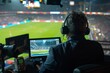 © ParinApril - Sports commentator at a soccer game in a broadcasting booth.