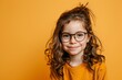 A child with glasses projecting confidence against a cheerful yellow background capturing the essence of optimism and energy