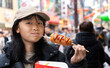 横浜中華街で食べ歩きをする日本人の女性