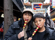 横浜中華街でいちご飴を食べる日本人の男の子と女の子