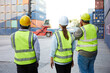 © offsuperphoto - back view workers or engineer using walkie talkie and showing gesture to crane car in containers warehouse storage