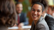 © RISHAD - Smiling woman in a business meeting.