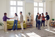© Studio Romantic - Cheerful smiling people friends or coworkers meeting in the living room together, talking, sharing news and stories with each other. Group of young students gathering at party at home.