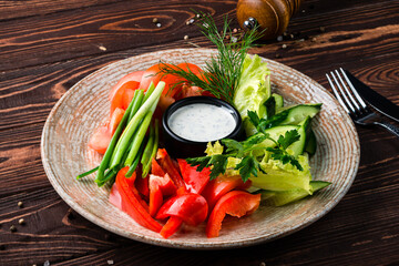 Poster - Fresh salad with cucumbers, lettuce, tomatoes, sweet pepper, green onion, parsley, dill and sauce on wooden table.