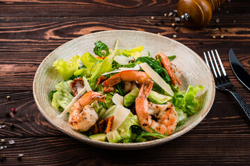 Wall Mural - Snack salad of shrimp, avocado, sun-dried tomatoes, parmesan cheese, lettuce and arugula.