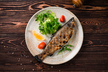 Canvas Print - Lunch grilled white fish with tomato, lemon, spices and herbs.