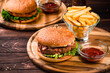 American food burgers with beef, chicken, bacon, tomato and lettuce with french fries and ketchup.