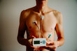 Candid capture of heart dynamics: EKG equipment on a young man, illuminated by the warmth of natural sunlight