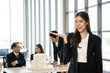© Bavorndej - A female architect gestures towards a scale model during a presentation to her colleagues in a modern office.