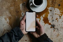 close-up photo of a smartphone with a coffee spill on it, lying on a wooden table