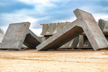 Wall Mural - Large reinforced concrete structures at the construction site. Preparation for the installation of reinforced concrete products. Construction work on the construction of foundations.