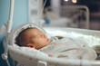 Newborn infant asleep in crib in delivery room