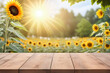Empty wooden table for product display with sunflower garden background