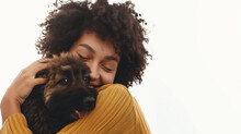 Woman cues joy cuddling with her adoring puppy, a moment of pure affection.