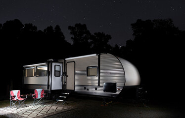 Wall Mural - forest silhouetted by stars with camping trailer