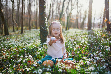 Wall Mural - Five year old girl playing egg hunt on Easter